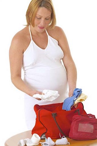 Femme enceinte préparant sa valise Femme enceinte préparant sa valise